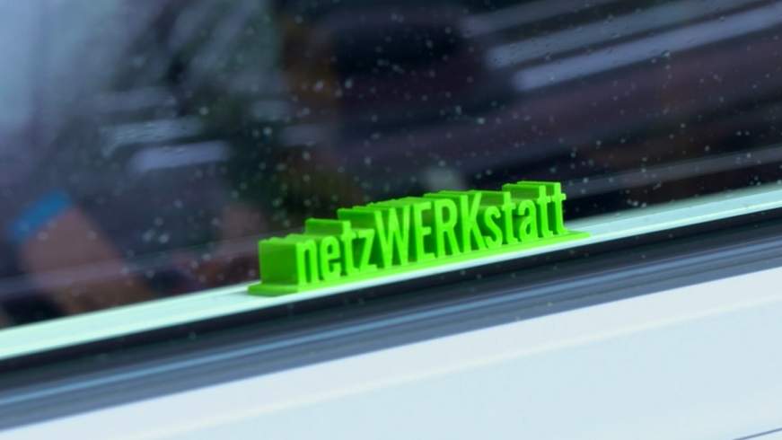 Bild des Schriftzuges Netzwerkstatt hinter einer Fensterscheibe