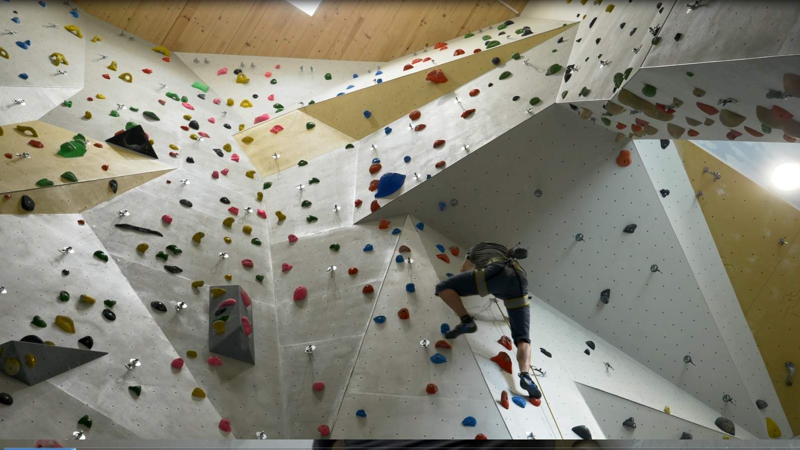 Innenaufnahme der Kletterhalle mit angeseiltem Kletterer