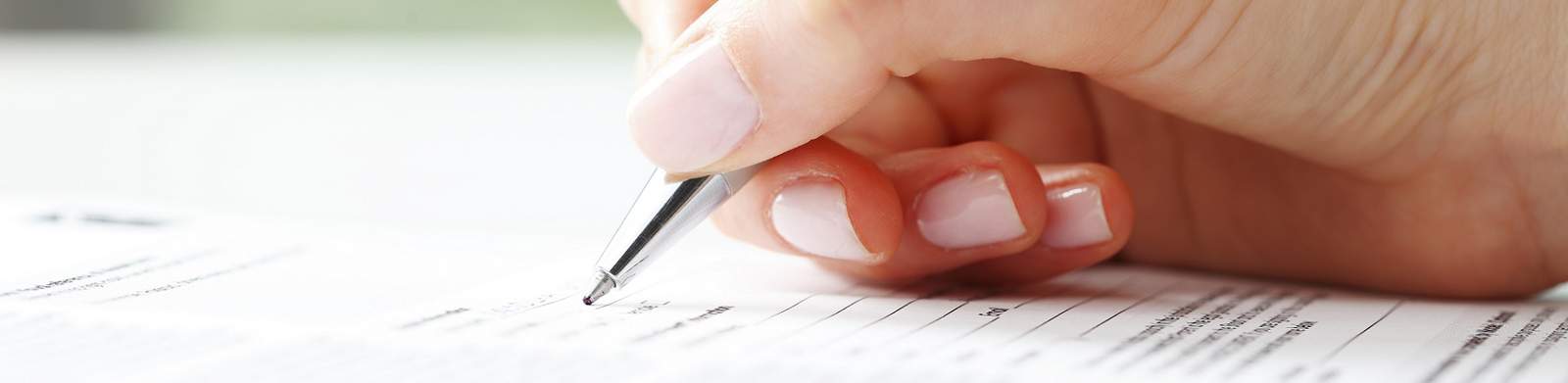 Bild einer auf Papier schreibenden Hand als Symbol für das Bestellformular