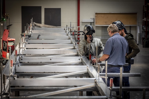 Foto von Mitarbeitern die über die Bearbeitung eines Tores sprechen