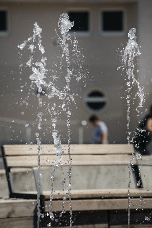 Foto von Wasserfontänen, im Hintergrund Sitzbänke
