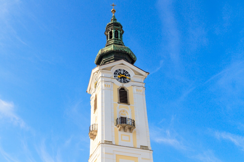 Foto eines Kirchturms vor blauem Himmel