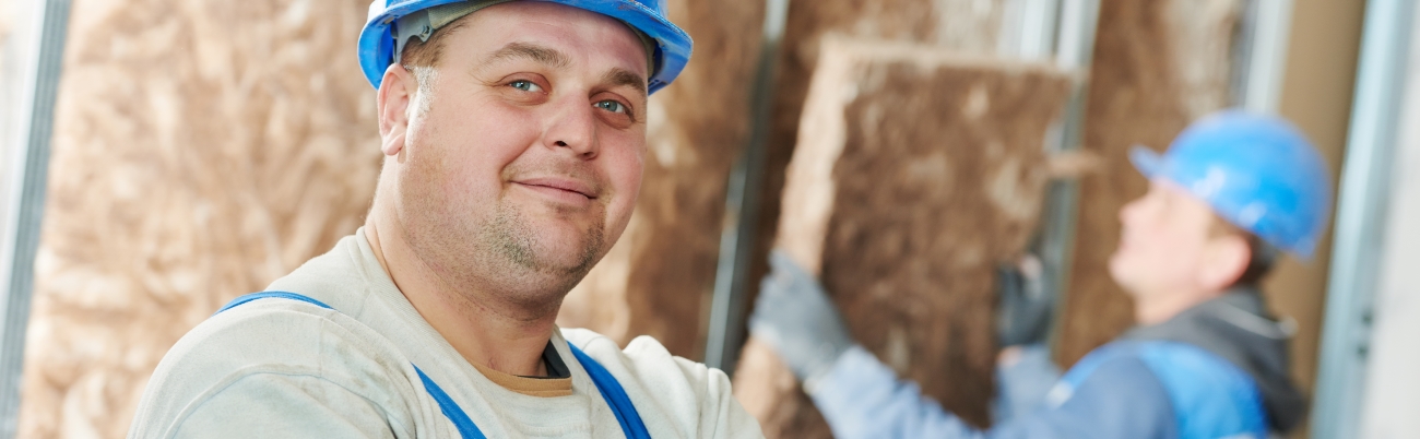 Foto von zwei Arbeitern beim Dämmen einer Innenwand