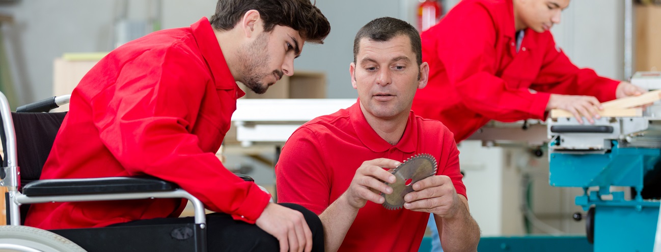Bild eines Arbeiters in Rollstuhl in einer Werkstatt
