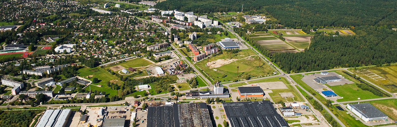 Die Luftaufnahme zeigt eine Kleinstadt mit Gewerbegebiet in ländlichem Umfeld. Stadt/Umlandentwicklung ist ein Schwerpunkt von IWB/EFRE in Österreich.