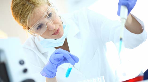 Forscherin füllt in modernem Labor mit Pipette in der Hand